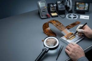 Flexible PCB assembly and installation precautions cover image with a realistic flex circuit on an electronics workbench.