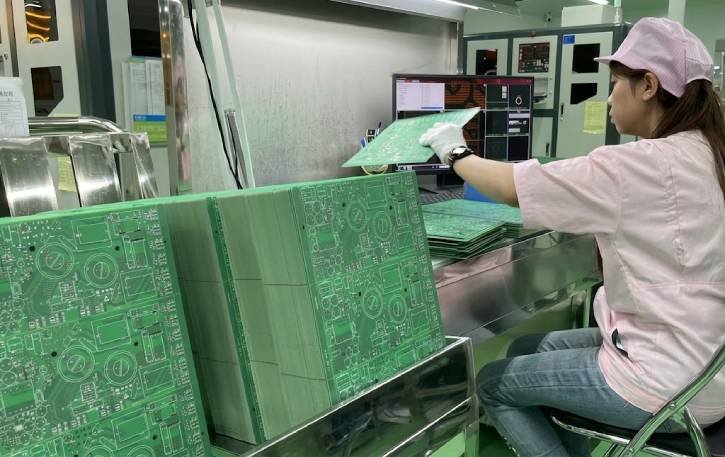PCB operator inspecting bare PCB panels at a China-based manufacturing facility