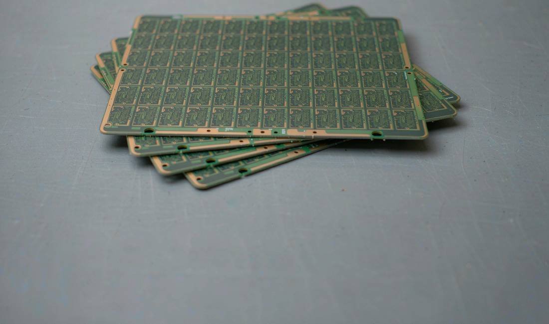 Matching bare PCB production panels arranged in a neat overlapping stack