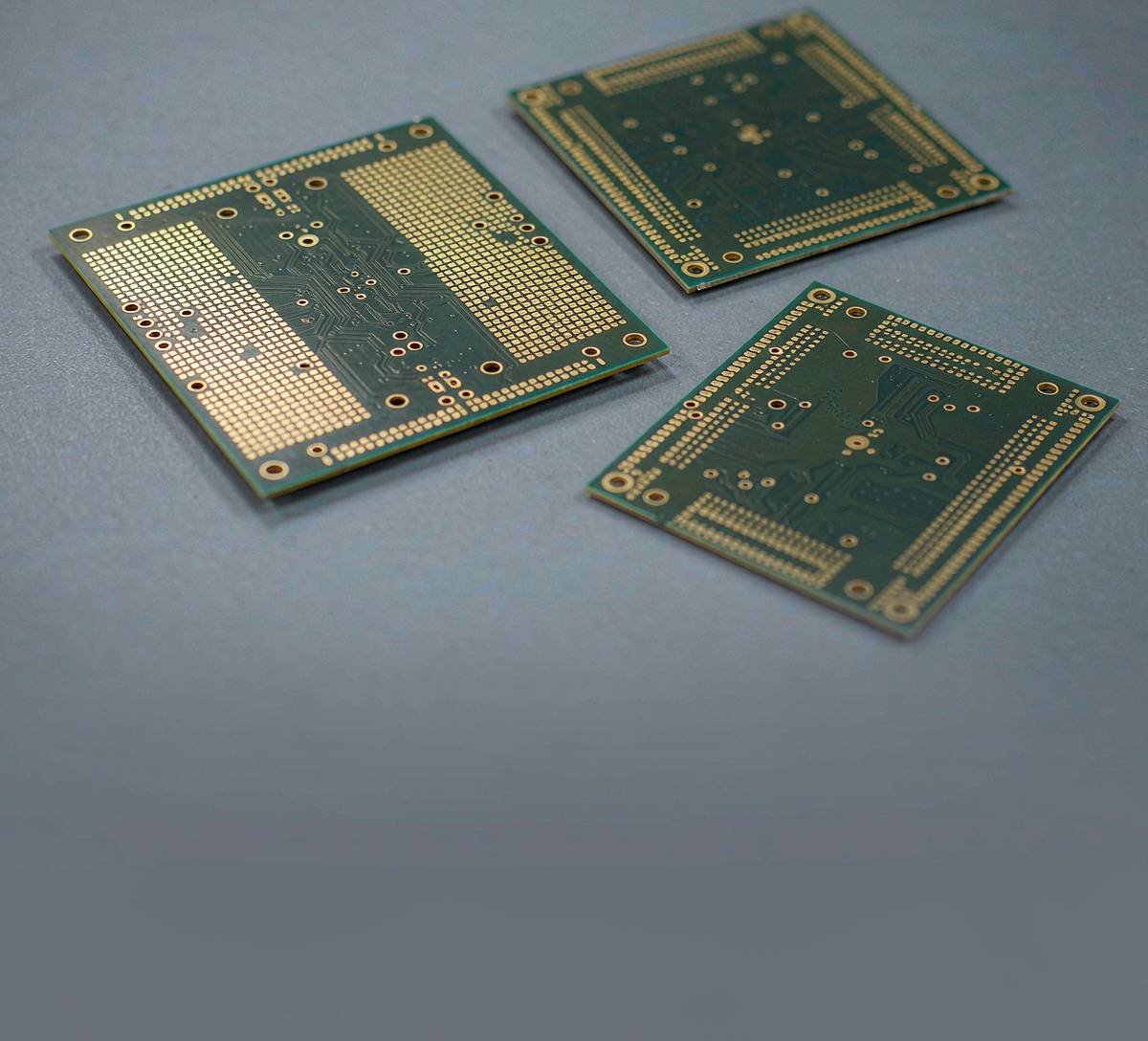 Unpopulated PCB prototype samples with green solder mask and exposed gold-colored pads