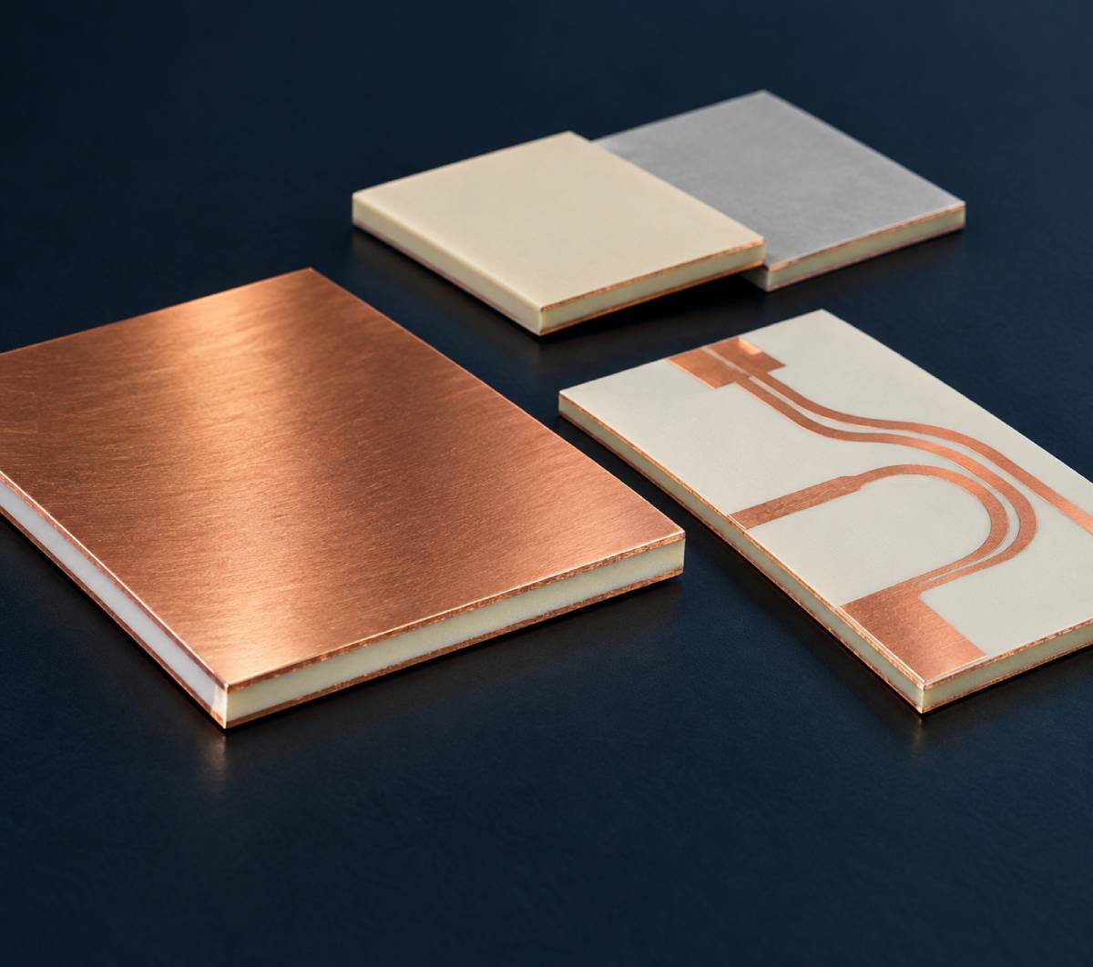 High-frequency copper-clad laminate samples showing dielectric edges and copper foil beside a bare RF circuit board